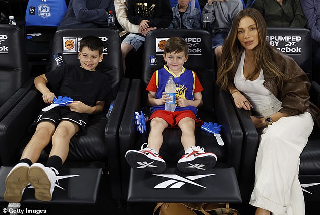 The fashionista rocked a low-cut white dress that hugged her curves as she took her seat courtside for the Melbourne United versus Cairns Taipans NBL match at John Cain Stadium.