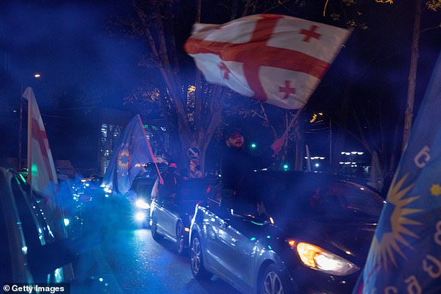 Supporters of the Georgian Dream Party celebrate the results of the exit poll in front of the new Georgian Dream headquarters during Georgia's election day on October 26, 2024 in Tbilisi, Georgia.