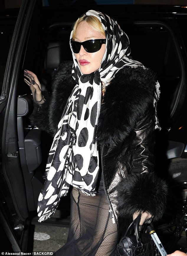 She added a bold black and white spotted scarf tied around her head as she left her hotel.