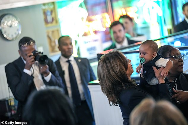 Kamala Harris hugs a baby at Freddy & Tony's Restaurant, a locally owned Puerto Rican restaurant in Philadelphia