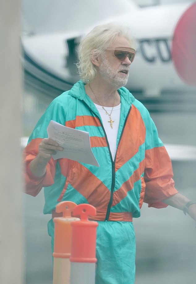 That's right, it's Bob Geldof! He looked a far cry from his normal appearance as he cut a vibrant figure in a bright orange and blue suit while channeling '90s fashion.