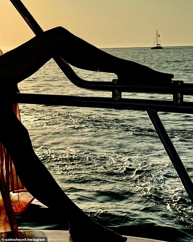 The From Dusk to Dawn star, 58, posed on the boat with the setting sun backlighting her.