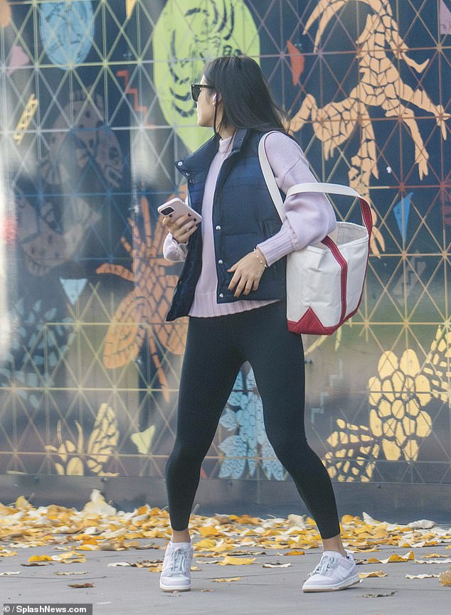 The brunette beauty donned a white and red clutch on the day.