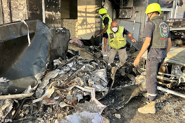 Members of the search and rescue team try to search for possible victims in a building damaged after an Israeli airstrike, in Tyre, Lebanon, on October 28, 2024.