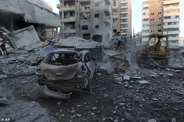 A rescuer uses an excavator to remove debris from buildings destroyed by Israeli airstrikes in Tyre, Lebanon, Monday, Oct. 28, 2024.