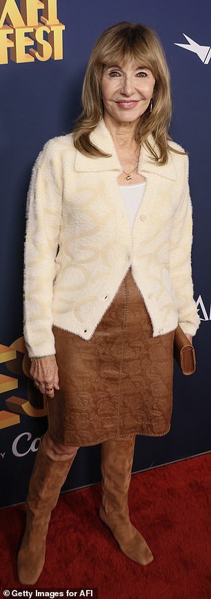 Steenburgen highlighted her fall look with a brown suede skirt, a light tan furry top over a white T-shirt, and dark brown knee-high boots.