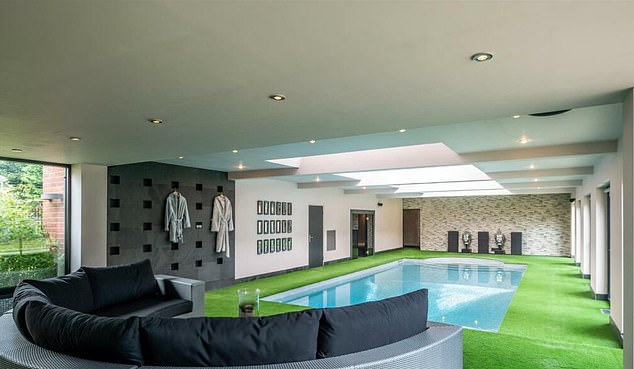 The luxury mansion contains an indoor swimming pool, surrounded by artificial grass and with a relaxing area nearby.