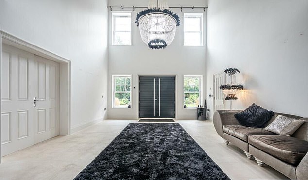 The huge entrance hall (pictured) to the home connects to the kitchen, which also functions as a dining room and family room, while the other side leads to a spacious living room.