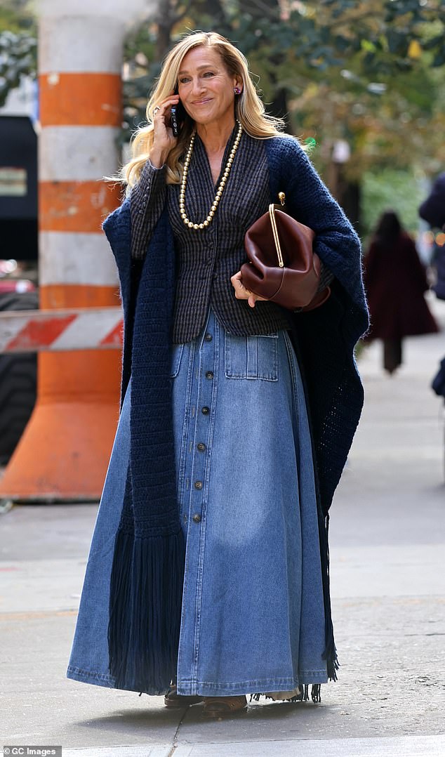 Parker wore a fitted, dark, patterned jacket under a navy knit shawl, adding a long, slightly billowy denim skirt.