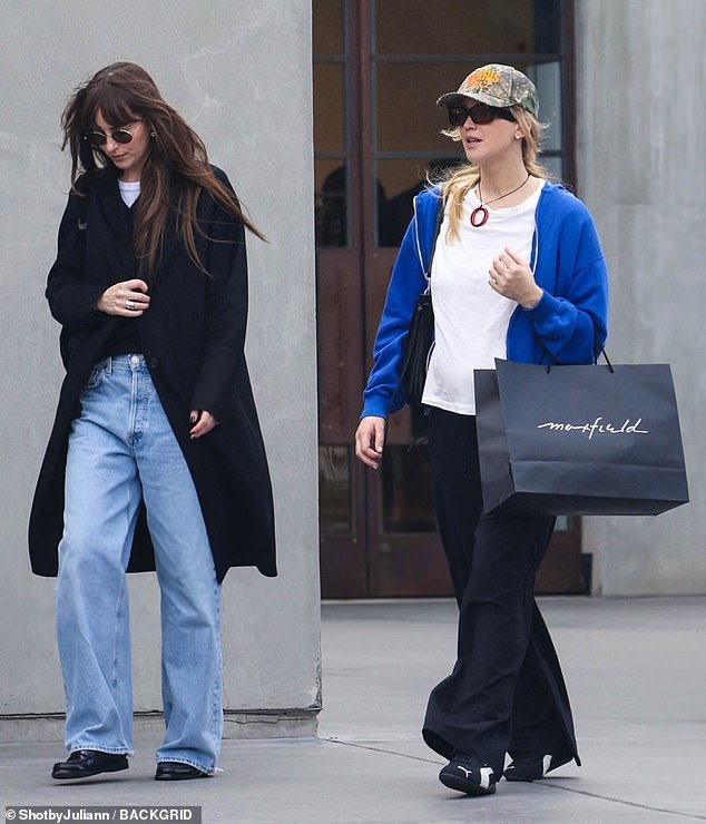 The Lost Daughter star wore light wash baggy jeans with a black coat.