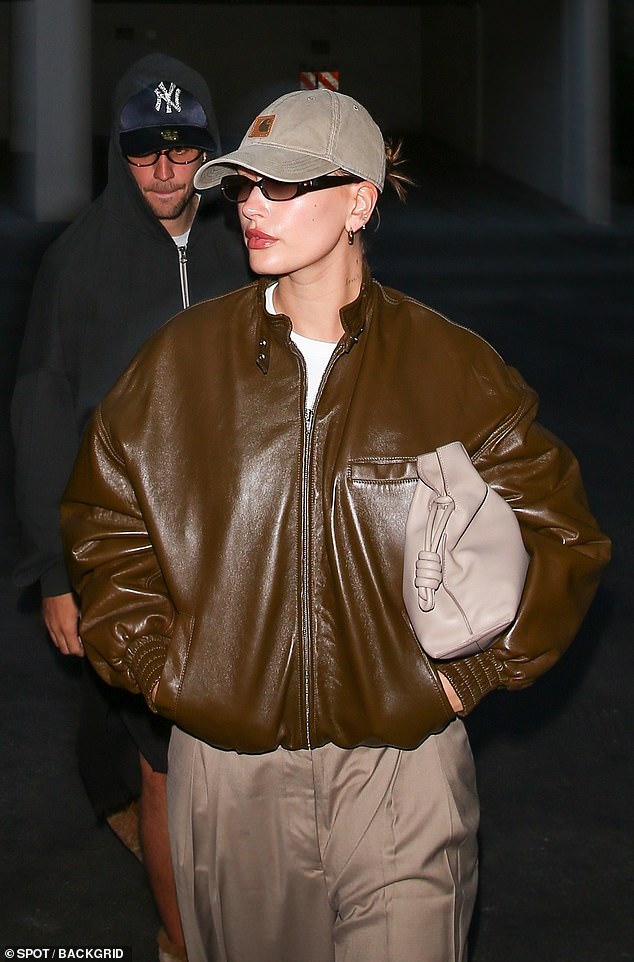 Hailey's casual look consisted of pants, shiny black boots, and a taupe leather bag.