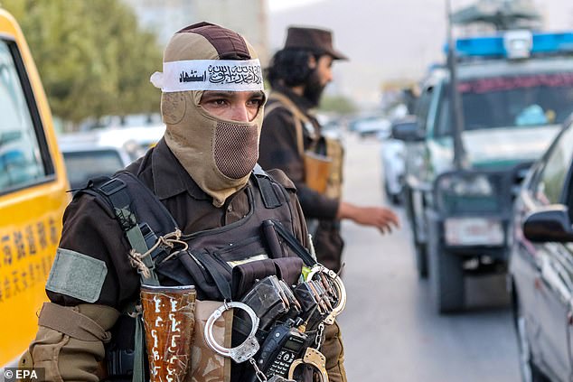 Taliban security officials stand guard while screening people and vehicles at a checkpoint, in Kabul, Afghanistan, on September 13, 2024.