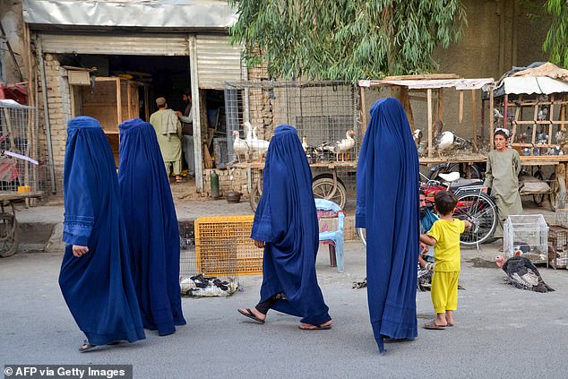 Afghan women dressed in burqas walk down a street in Kandahar on September 3, 2024