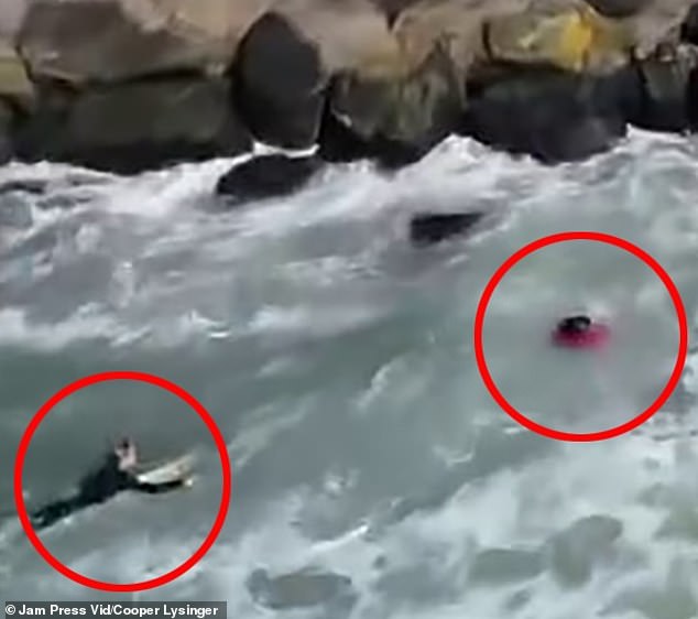 As he approached the man, he was able to grab him and drag him to the safety of his own surfboard.