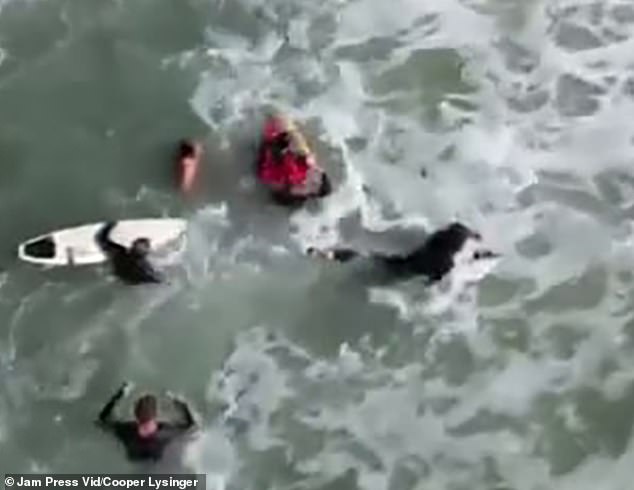 Other surfers were then seen in the footage paddling towards Lysinger in an attempt to help.