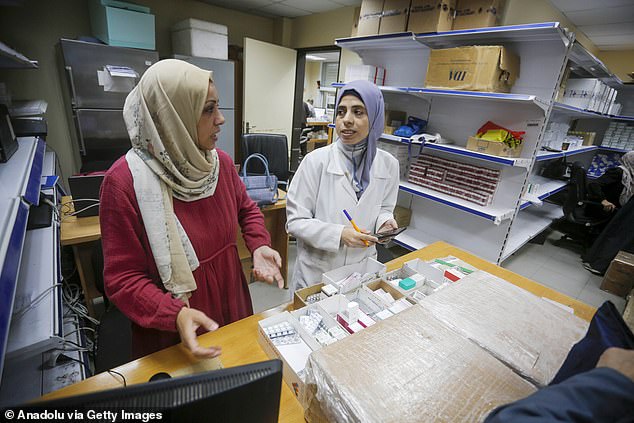 Two doctors dispensing medicines at the UNRWA centre. Labor and Conservative stalwarts questioned whether ministers were using all available options to force Israel to act.