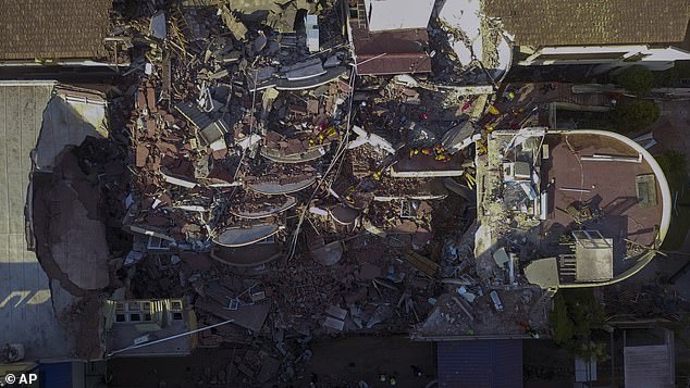 Firefighters and rescuers work to find survivors in the rubble of the partially collapsed Hotel Dubrovnik, in Villa Gesell, Argentina.