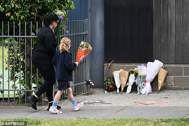 A student is seen leaving flowers at the crash site on Wednesday