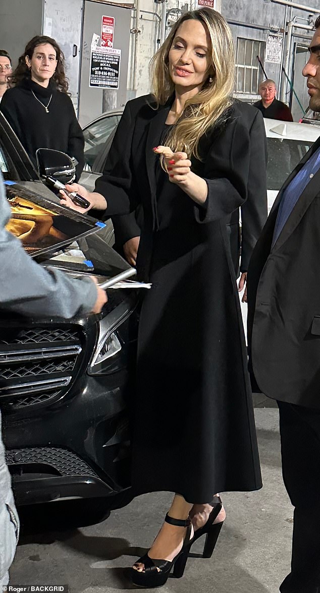 Angelina had a big smile on her face as she walked towards the theater entrance and took the time to sign autographs for the fans waiting outside.