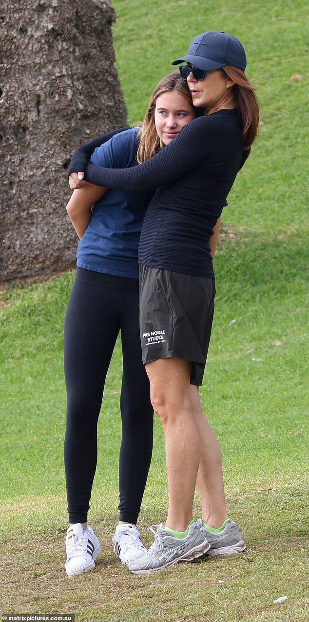 The Queen snuggled up with her daughter who was wearing black tights and a blue T-shirt