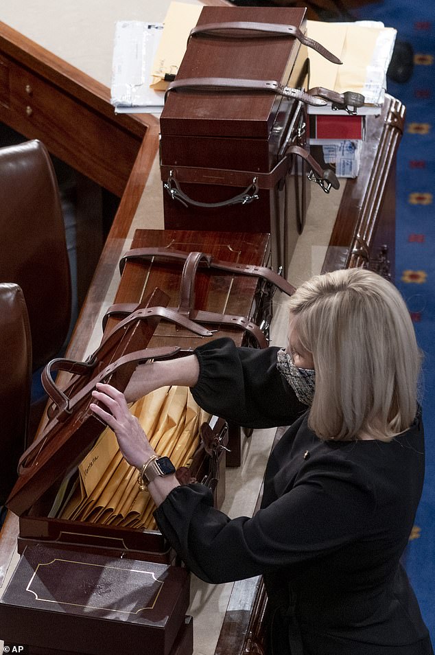 Boxes containing Electoral College votes from the 2020 election are opened during a joint session of the House and Senate on January 6, 2021.