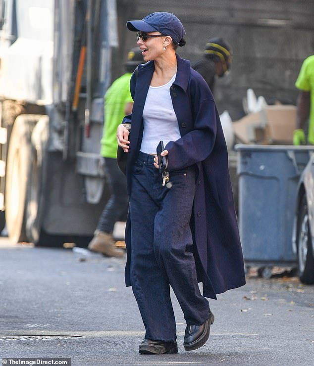 For her relaxed outing, the actress wore a navy coat, matching pants, a white tank top, and sneakers.