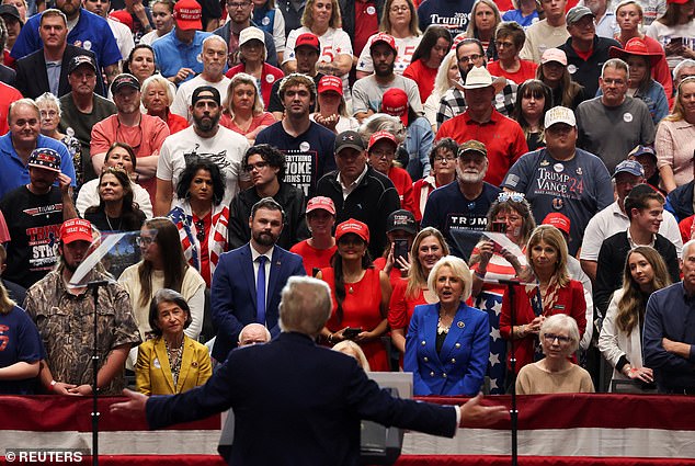 Supporters listen to Republican presidential candidate and former US President Donald Trump speak during a campaign rally in Rocky Mount.