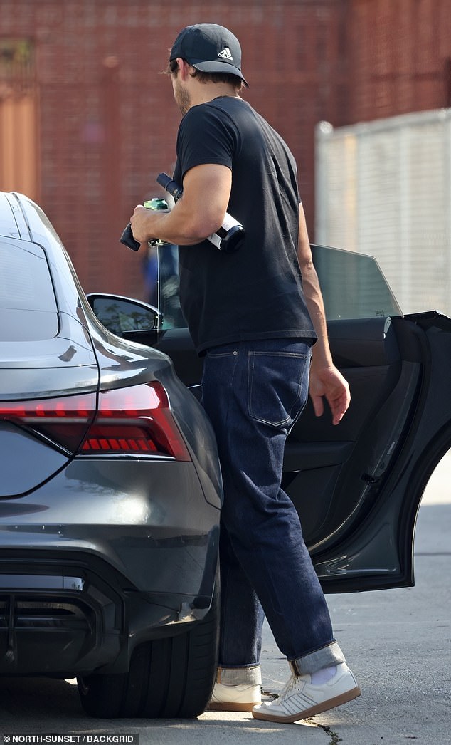 For the outing, Tom looked casual in a black T-shirt and dark pants, which he paired with white sneakers while carrying groceries.