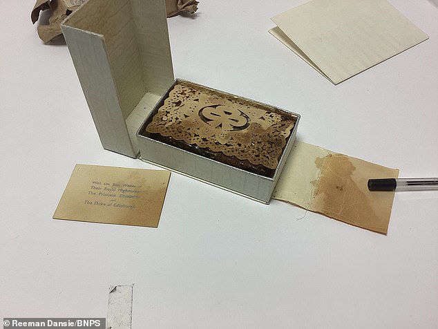 The cake is seen covered by a piece of patterned paper. It is expected to sell for up to £500.