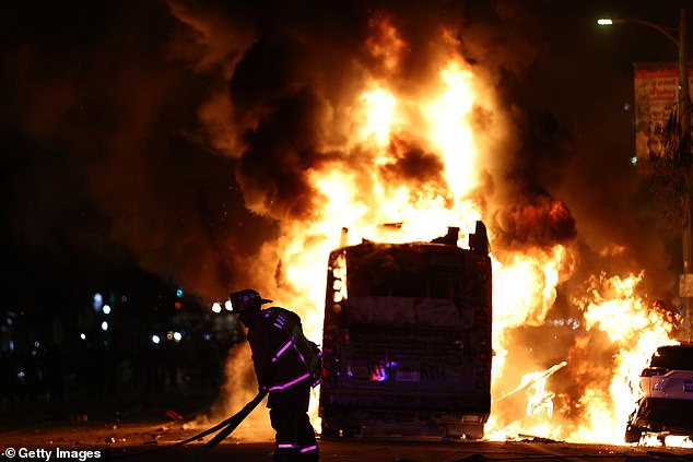 Firefighters pictured battling the blaze after a bus was set alight amid the celebrations.