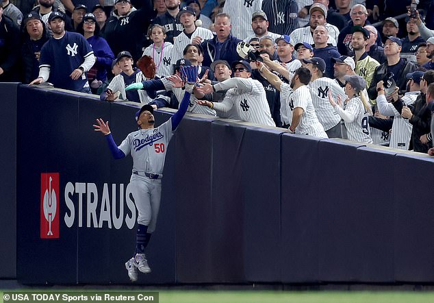 The fan was near the fan who tried to rip the ball out of Mookie Betts' glove.