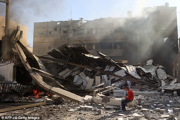 A Palestinian child sits on the rubble of the destroyed Maghazi Camp Services Club building following an Israeli attack on the Maghazi refugee camp in the Gaza Strip on October 24, 2024.