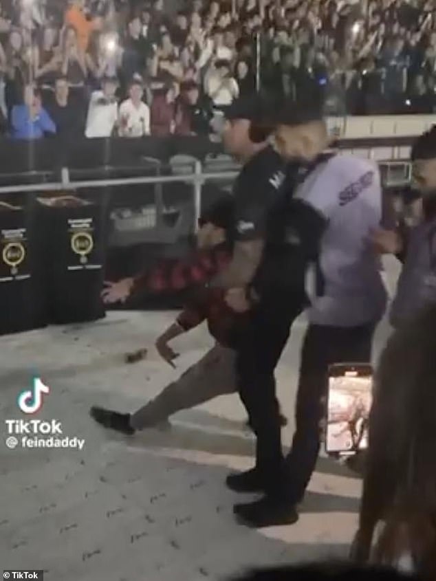 Footage of the incident was later shared on Tik Tok and shows a security guard holding the concert-goer under his arms as the man shakes uncontrollably. (Pictured)