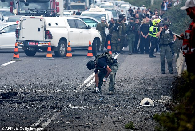 Air raid sirens sound across northern and central Israel, as Hezbollah unleashes new rounds of missile attacks on the Jewish state and the Israel Defense Forces conduct raids into Lebanon, vowing to uproot the terrorist group from their shared border. . (Above) Israeli security forces inspect damage caused by a rocket allegedly launched from Lebanon on October 1, 2024.