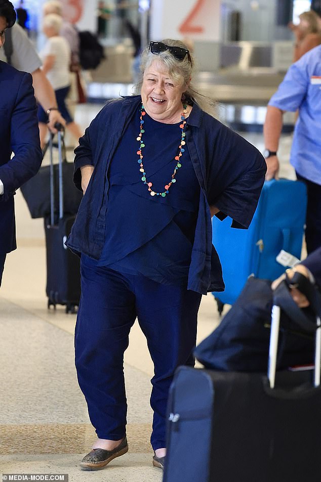 She completed her look with comfortable gray shoes and wore a colorful necklace.