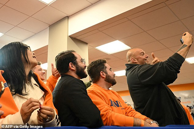 Pennsylvania Sen. John Fetterman (R) takes a selfie with LiUNA union workers at an event in downtown Pittsburgh on Saturday with President Joe Biden in support of Vice President Kamala Harris.