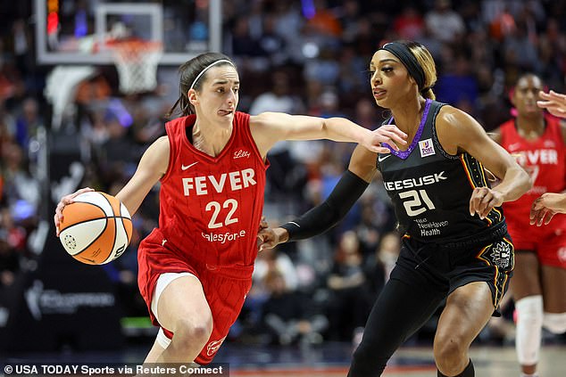 Fever guard Caitlin Clark (22) drives to the basket defended by Sun guard DiJonai Carrington