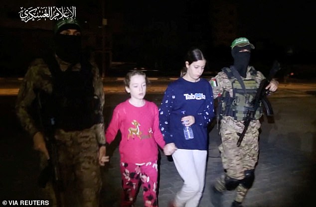 Emily is taken to safety by armed Hamas militants after 50 days in captivity.