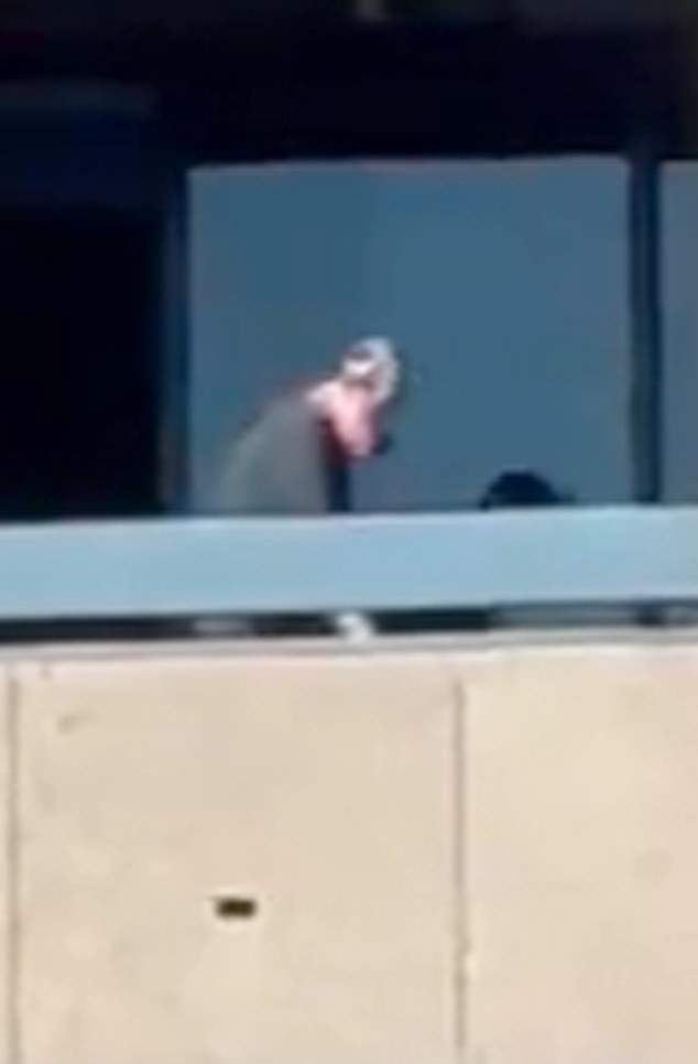 The unidentified shooter, wearing a pale rubber mask, fired a rapid-fire burst toward people filming him from another balcony just as the clip ends.