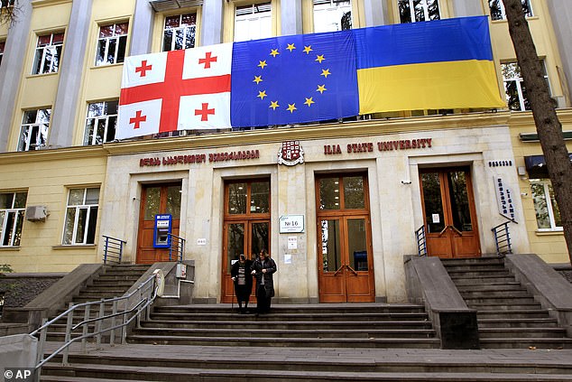 From left: National flags of Georgia, the EU and Ukraine hang at a polling station during the parliamentary elections in Tbilisi, Georgia, Saturday, October 26, 2024.