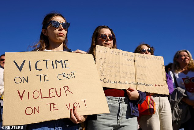 A woman holds a sign that says: 