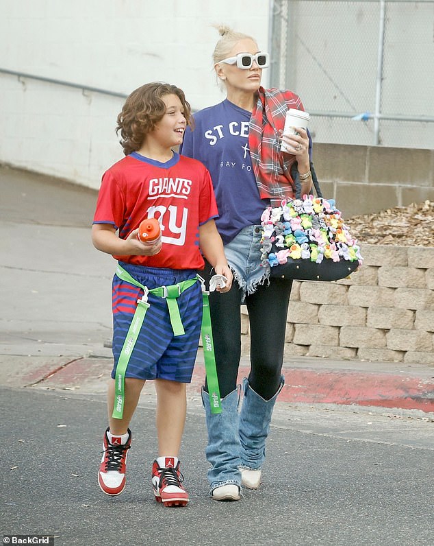 She modeled an oversized navy blue shirt paired with denim shorts paired with leggings and denim cowboy boots.