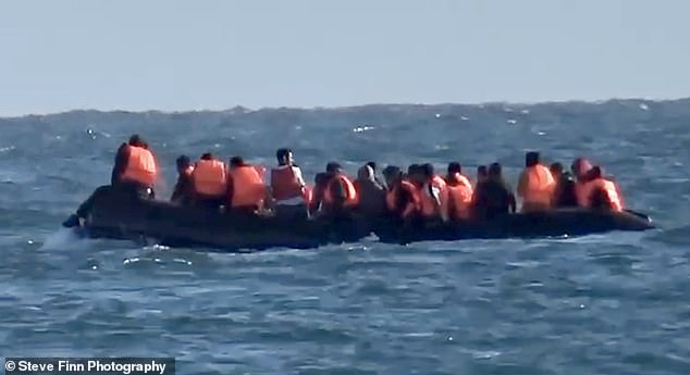 A large group of migrants attempting to cross the English Channel is seen yesterday in a small boat.