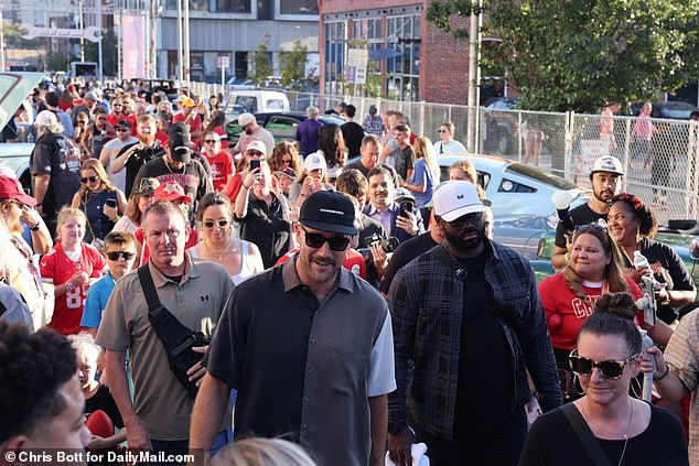 A crowd of fans follows Travis Kelce after his arrival at his charity event on Saturday night.