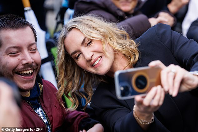 The Oscar-winning actress, 49, looked in high spirits as she stopped to pose for selfies with fans outside the theater.