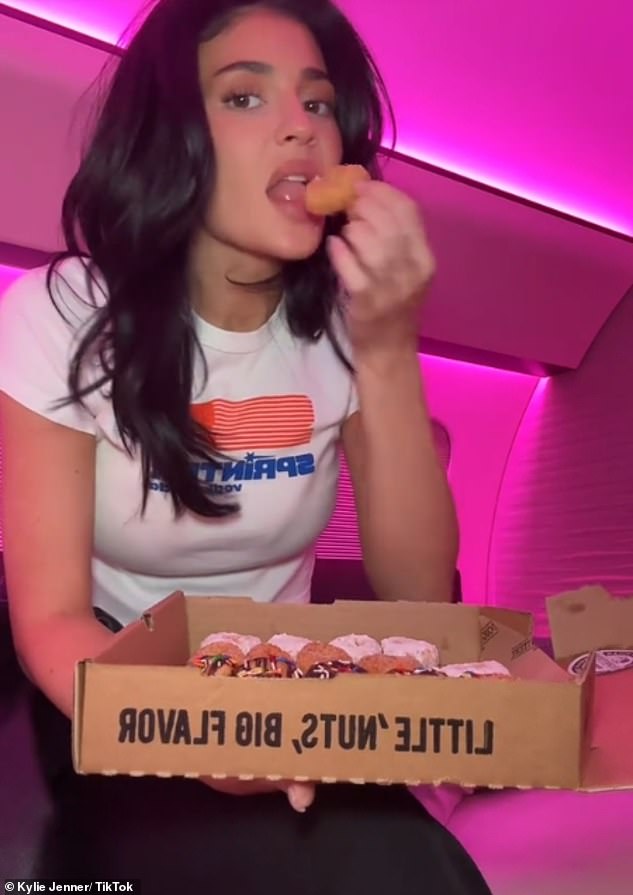 Kylie lay in the bed of her private jet eating donuts while catching up on the BBC show on her iPad.