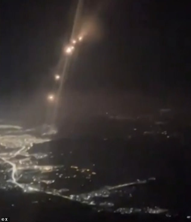 Terrifying images taken from the cockpit of a plane flying over the Middle East showed the moment a barrage of Iranian missiles streaked through the night sky near a passenger plane.