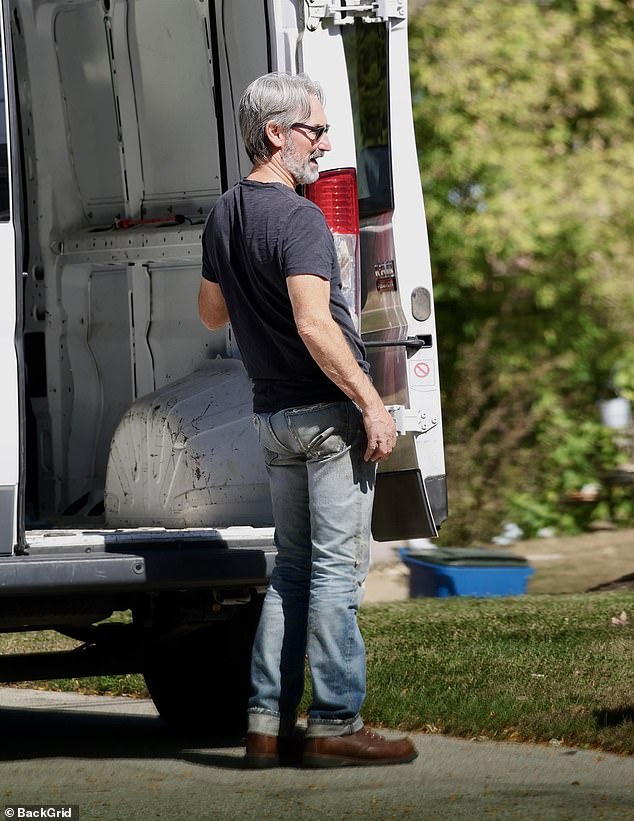 The antiques and collectibles collector looked grim as he moved furniture from his white van. She wore a navy blue t-shirt with blue jeans and brown boots for the outing.