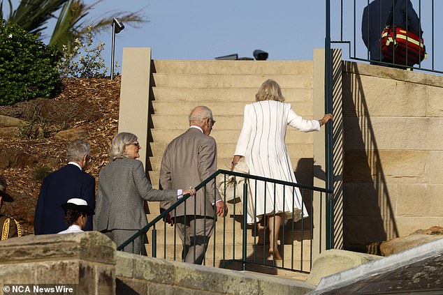 She was seen barefoot as she walked up the pier stairs with one hand on the railing and the other holding her heels, bag and coat.