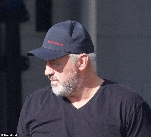 On Tuesday, he wore a black cap with a black V-neck shirt and blue jeans.